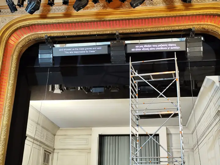 Two surtitle screens in the proscenium, Greek and English.